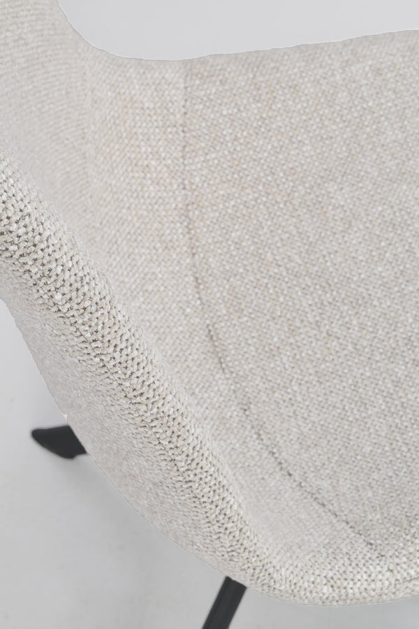 Närbild på vit stol med texturerat tyg och svarta metallben