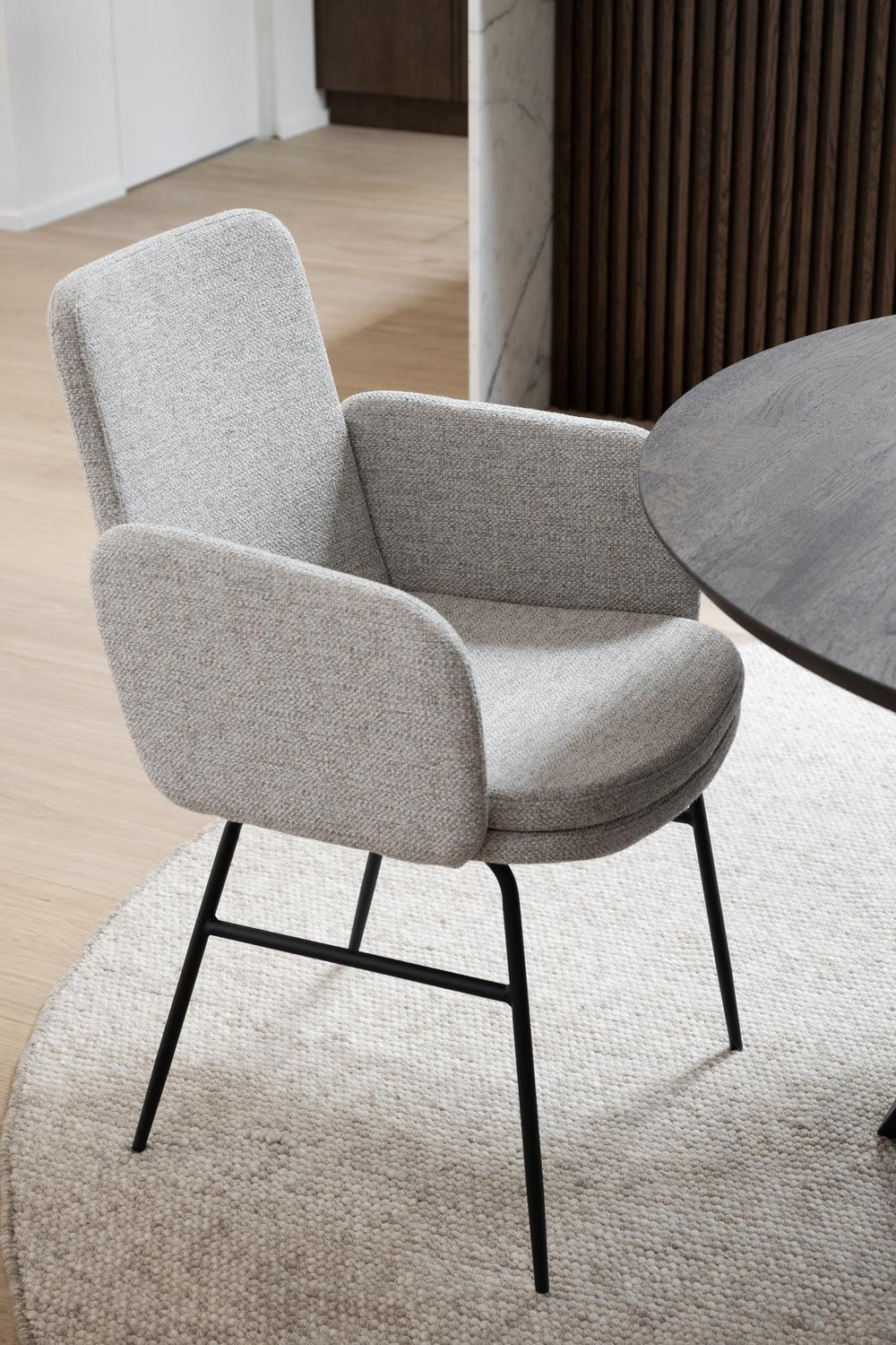 Beige stol med armstöd och svarta metallben, frontvy mot vit bakgrund