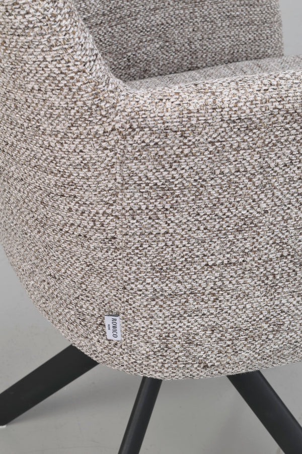 Närbild på beige fåtölj med textilklädsel och svarta träben, samt en vit etikett med texten "ROWICO"