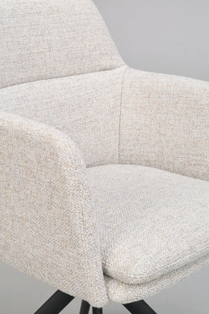 Närbild på beige fåtölj med mjuk klädsel och svarta träben, visar sits, armstöd och ryggstöd