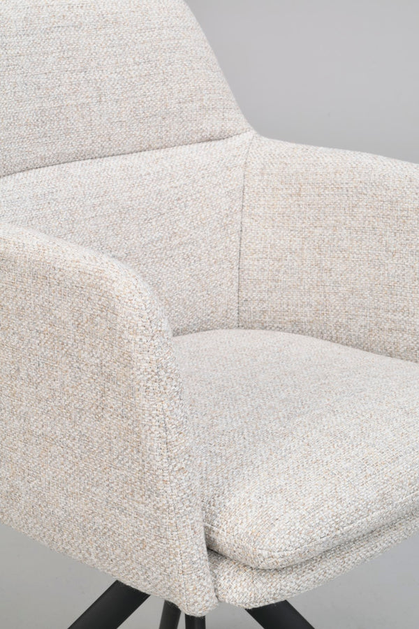 Närbild på beige fåtölj med mjuk klädsel och svarta träben, visar sits, armstöd och ryggstöd