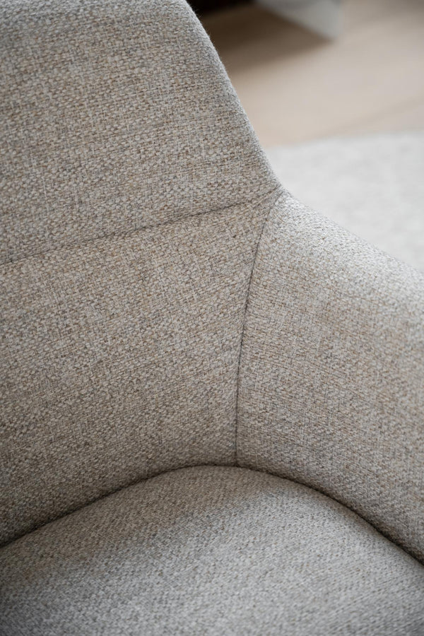 Närbild på grå stol med textilklädsel och mjuka kurvor, detalj av sits och ryggstöd