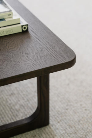 Närbild på mörkgrått soffbord med trästruktur och metallunderrede, böcker på bordet
