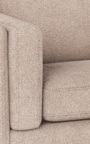 Beige soffa i nära detalj med mjuk klädsel och rundad armstöd