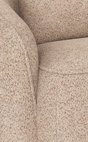 Beige boucléfåtölj med mjuk textur och rundade armstöd, närbild av sits och armstöd