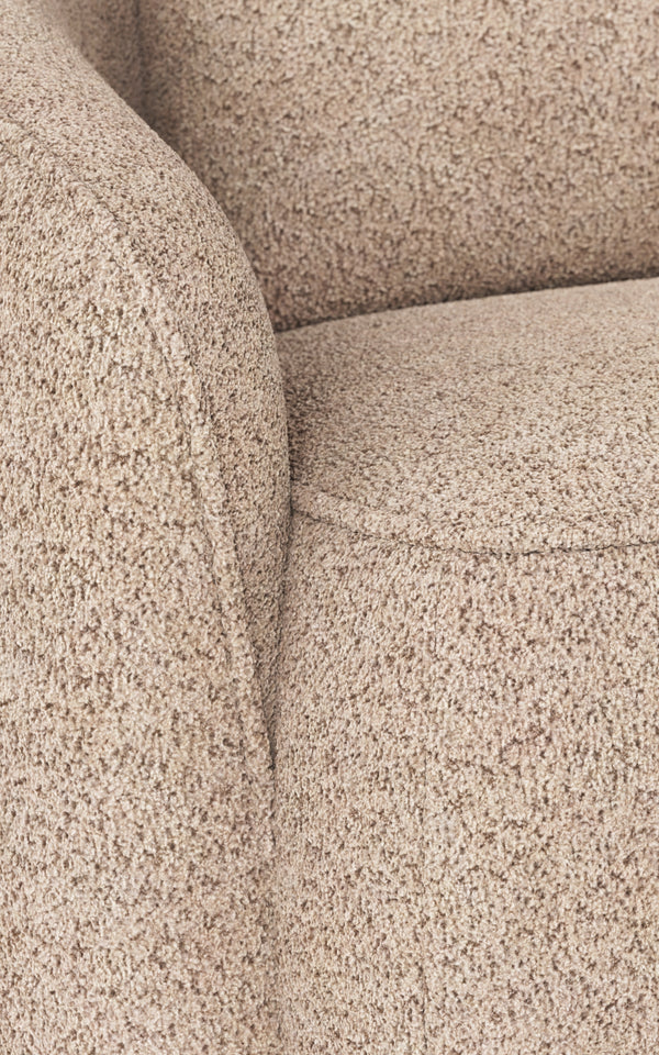 Beige boucléfåtölj med mjuk textur och rundade armstöd, närbild av sits och armstöd