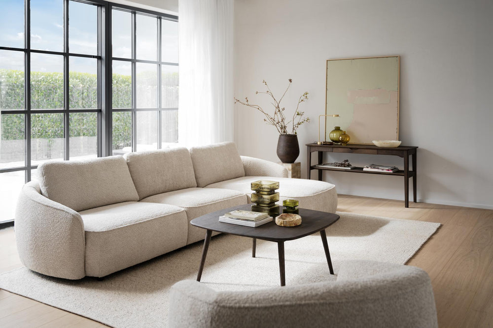 Beige modulsoffa med schäslong i bouclétyg, tre sittplatser och rundade armstöd