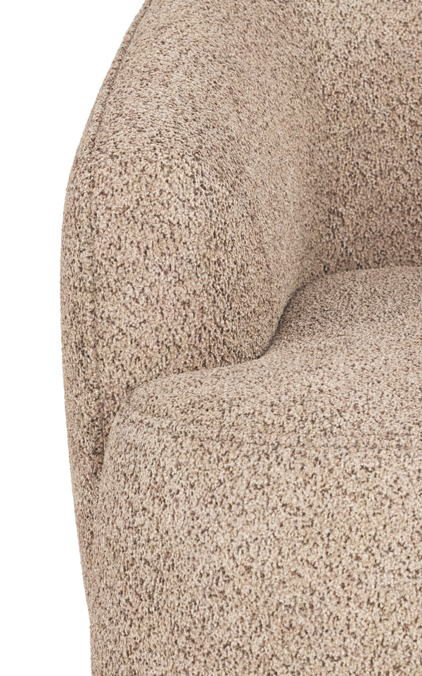 Närbild på beige bouclé fåtölj med mjuk, texturerad klädsel och rundad armstöd