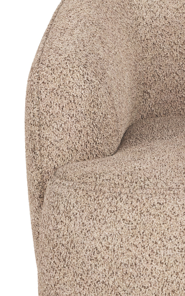Närbild på beige boucléfåtölj med mjuk texturerad klädsel och rundad armstöd