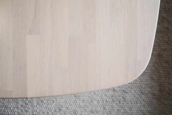 Ljust trägolv i ek med naturlig struktur på grå matta, närbild av golvplankor