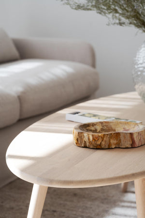 Rund soffbord i ljust trä med naturlig träskiva och bok i skandinavisk vardagsrumsinredning