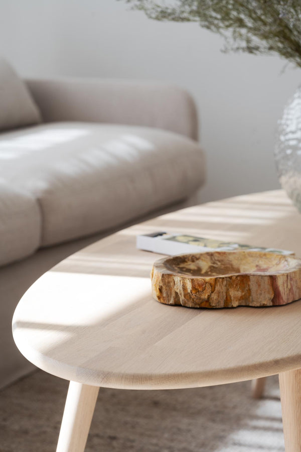 Rund soffbord i ljust trä med naturlig träskiva och bok i skandinavisk vardagsrumsinredning