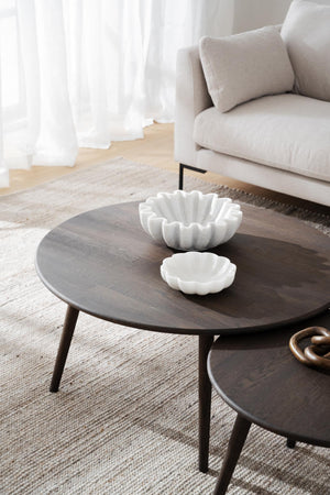 Runda soffbord i mörkt trä med vita dekorativa skålar i vardagsrum med beige soffa