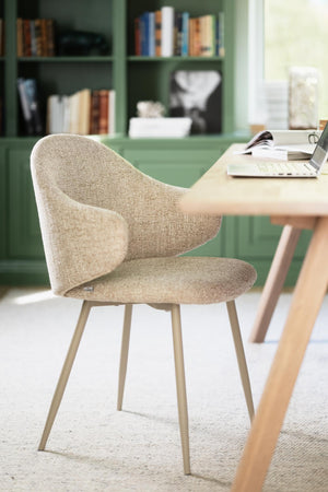 Beige stol med armstöd och träben vid skrivbord i modernt hemmakontor med grön bokhylla