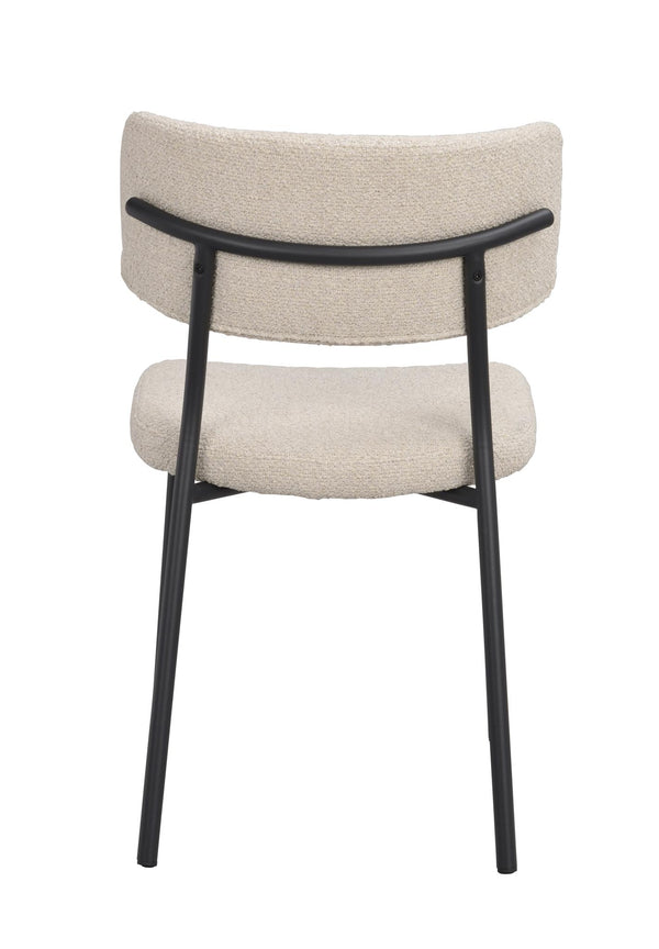 Matstol med beige klädsel och svart metallstomme, sedd bakifrån