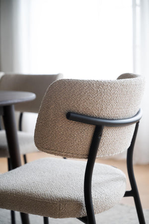 Boucléstol med svart metallram och beige/grå textilklädsel, modern matsalsstol i skandinavisk design