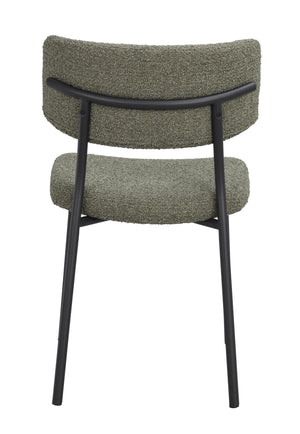 Grön stol med svart metallram sedd bakifrån, kuddig rygg och sits i bouclé-tyg