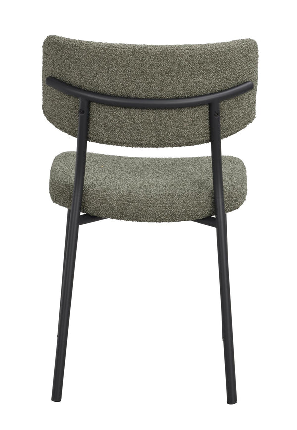 Grön stol med svart metallram sedd bakifrån, kuddig rygg och sits i bouclé-tyg