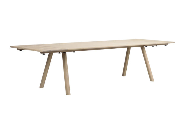 Ljust trä matbord med snedställda ben och förlängningsfunktion i modern skandinavisk design