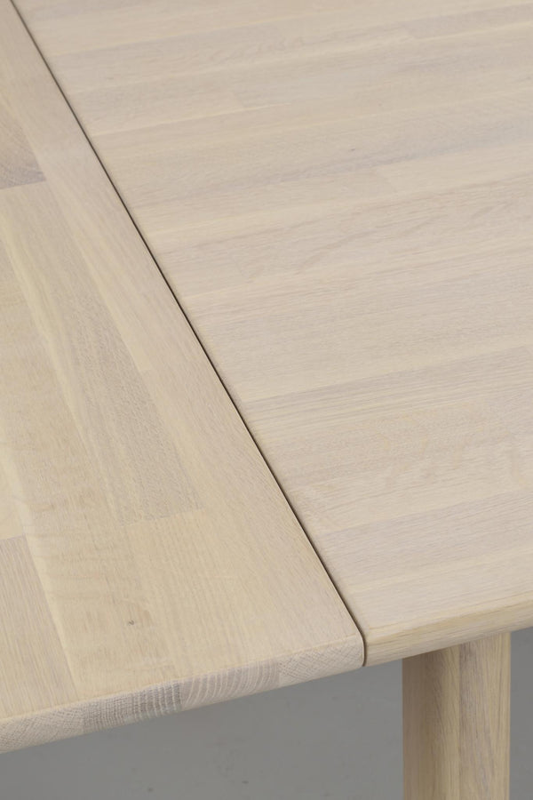 Närbild på ljust träbord med rundad kant och synlig trästruktur, modern skandinavisk design