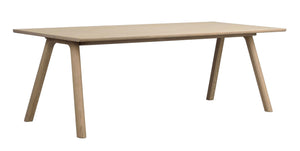 Matbord i ljust trä med fyra sneda ben och rektangulär bordsskiva i skandinavisk design