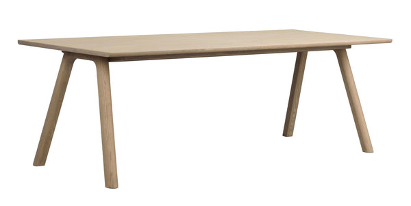 Matbord i ljust trä med fyra sneda ben och rektangulär bordsskiva i skandinavisk design
