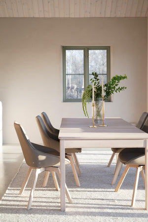 Matgrupp med grått bord och beiga stolar i modern skandinavisk stil med växter som dekoration