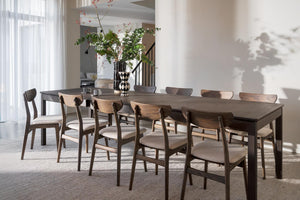 Matbord i mörkt trä med matchande stolar i skandinavisk design, idealiskt för större matsalar