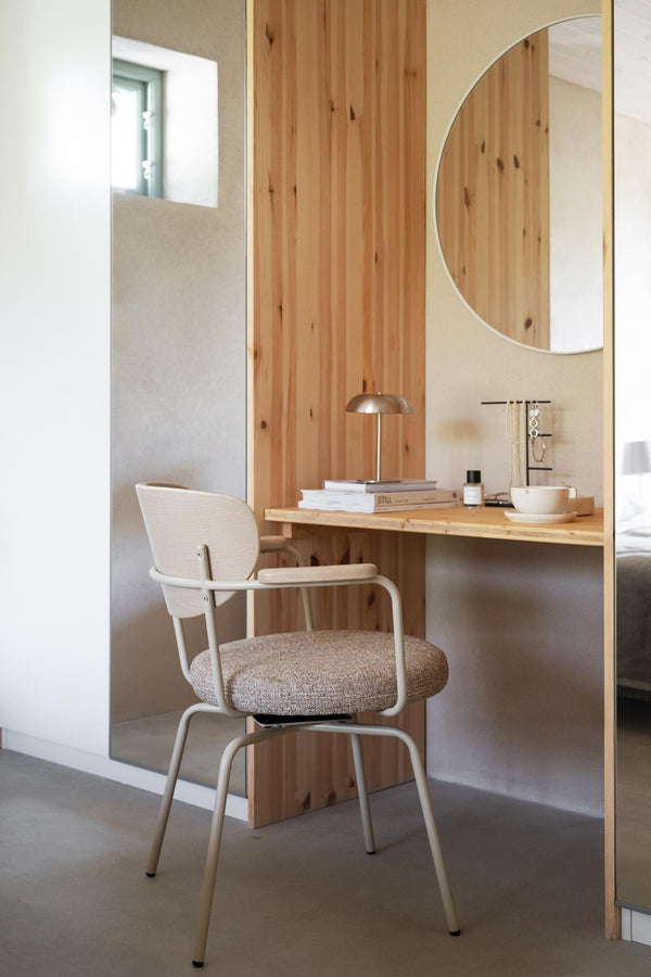 Ljus skrivbordsstol med armstöd och beige stoppad sits vid träskrivbord med rund spegel