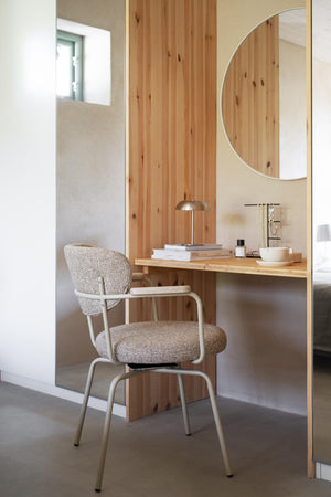 Skrivbord i ljust trä med stol i beige tyg, rund spegel och dekorativ bordslampa i modern skandinavisk stil