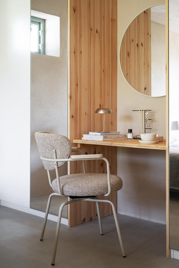 Skrivbord i ljust trä med stol i beige tyg, rund spegel och dekorativ bordslampa i modern skandinavisk stil