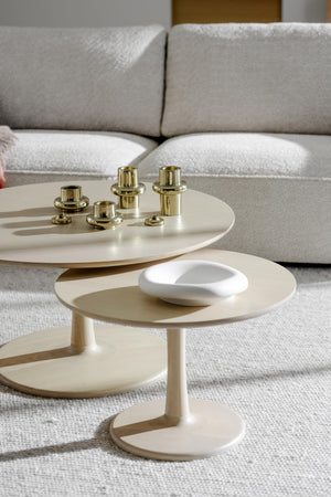 Moderna soffbord i beige med gulddetaljer framför grå soffa i ljust vardagsrum