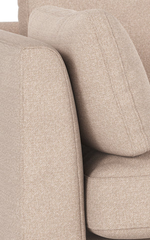 Beige fåtölj med stoppad armledare och mjuk klädsel i närbildsvy