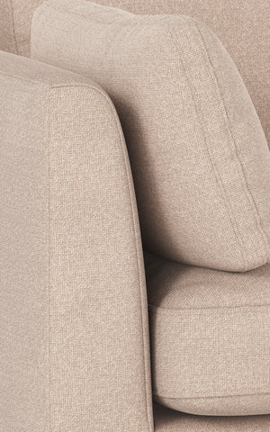 Beige stoppad fåtölj med mjuka rundade former och strutformad rygg i linnelikanande tyg