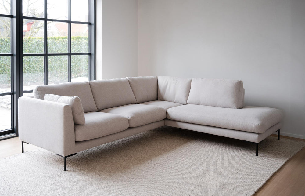 Beige hörnsoffa med schäslong och svarta metallben, modern design med tre sittplatser
