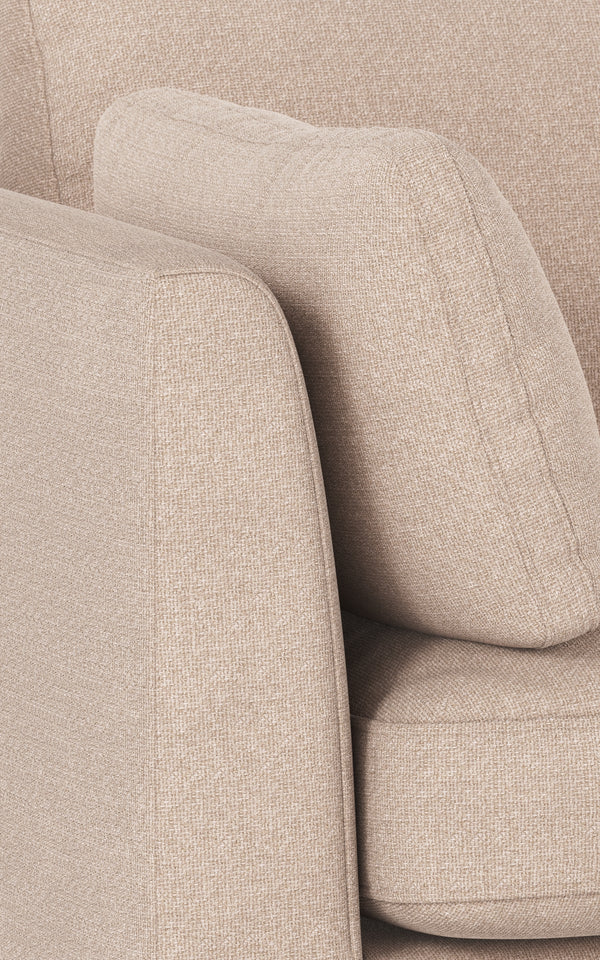 Beige fåtölj med mjuka rundade armstöd och klädsel i linneblandning, närbildsdetalj av komfort och design