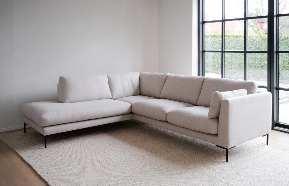 Beige hörnsoffa med schäslong och svarta metallben, modern design med mjuka dynor