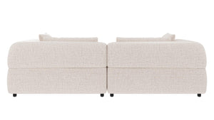 Beige modulsoffa i två delar med kuddar, sedd bakifrån mot vit bakgrund