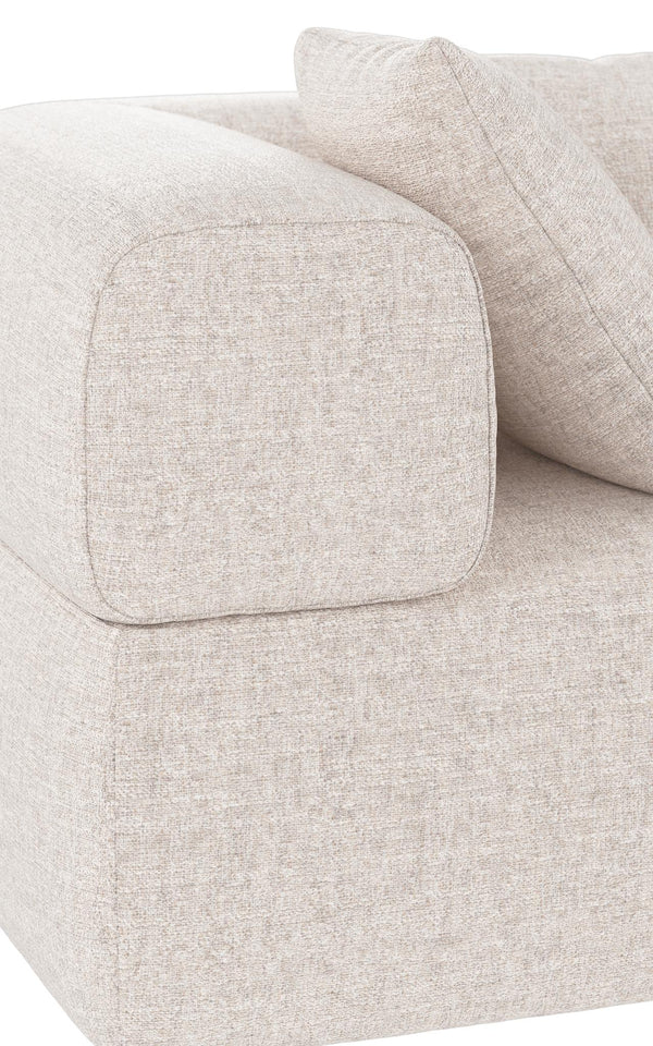 Beige soffa med mjuka kuddar och rundade armstöd i ljust tyg