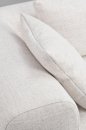 Närbild av ljusbeige soffa med mjuk klädsel och kuddar i linnelook