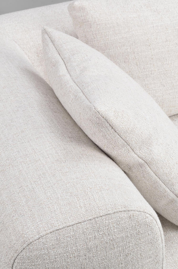 Närbild av ljusbeige soffa med mjuk klädsel och kuddar i linnelook