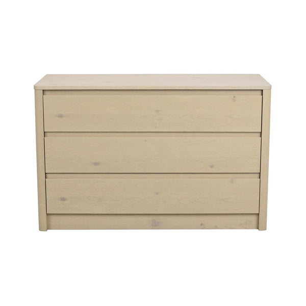 Ljus träbyrå med tre lådor i skandinavisk design, frontvyn mot vit bakgrund