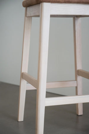 Närbild på ljusa träben och tvärslåar på en träpall eller barstol med naturligt trä