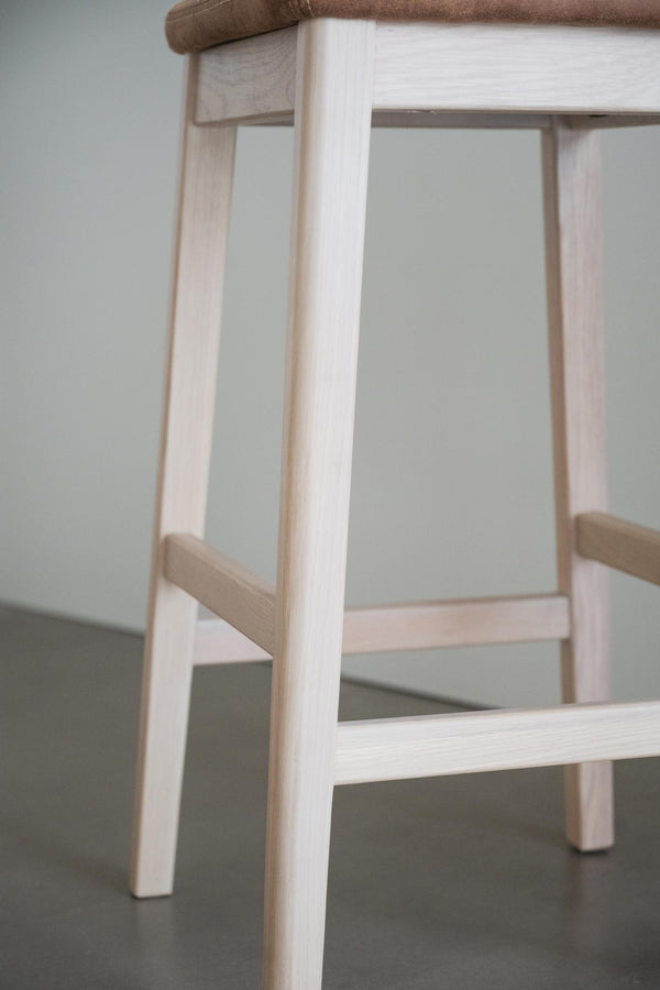 Närbild på ljusa träben och tvärslåar på en träpall eller barstol med naturligt trä