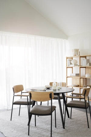 Matgrupp med svart runt bord och fyra stolar i ek och grå textilklädsel i minimalistisk matsal