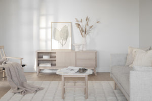 Ljust vardagsrum med beige TV-bänk, soffbord, fåtölj och dekoration i skandinavisk stil