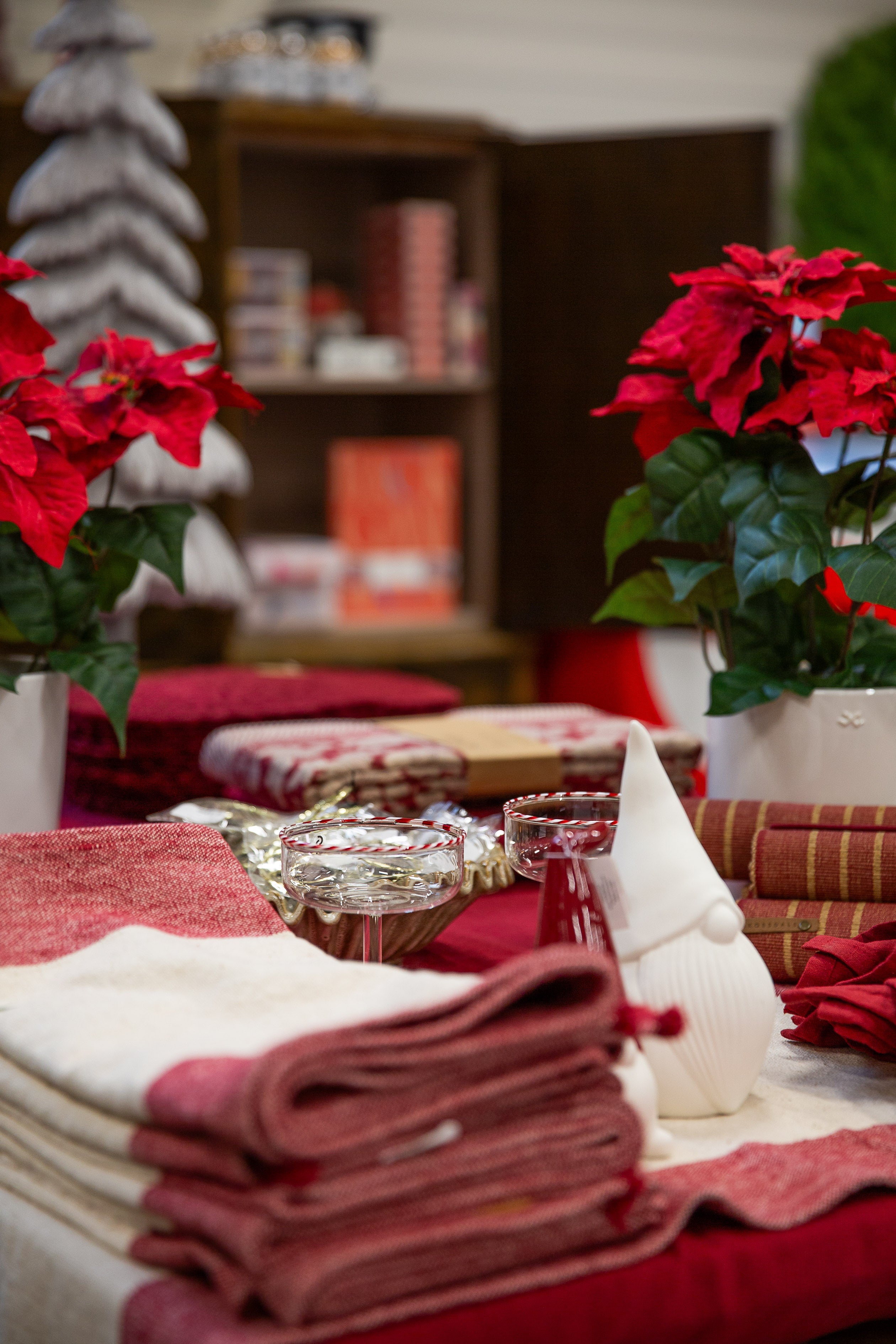 Röda julstjärnor och vackert dukad jultavla med textilier i rött och vitt, festlig bordsdekoration