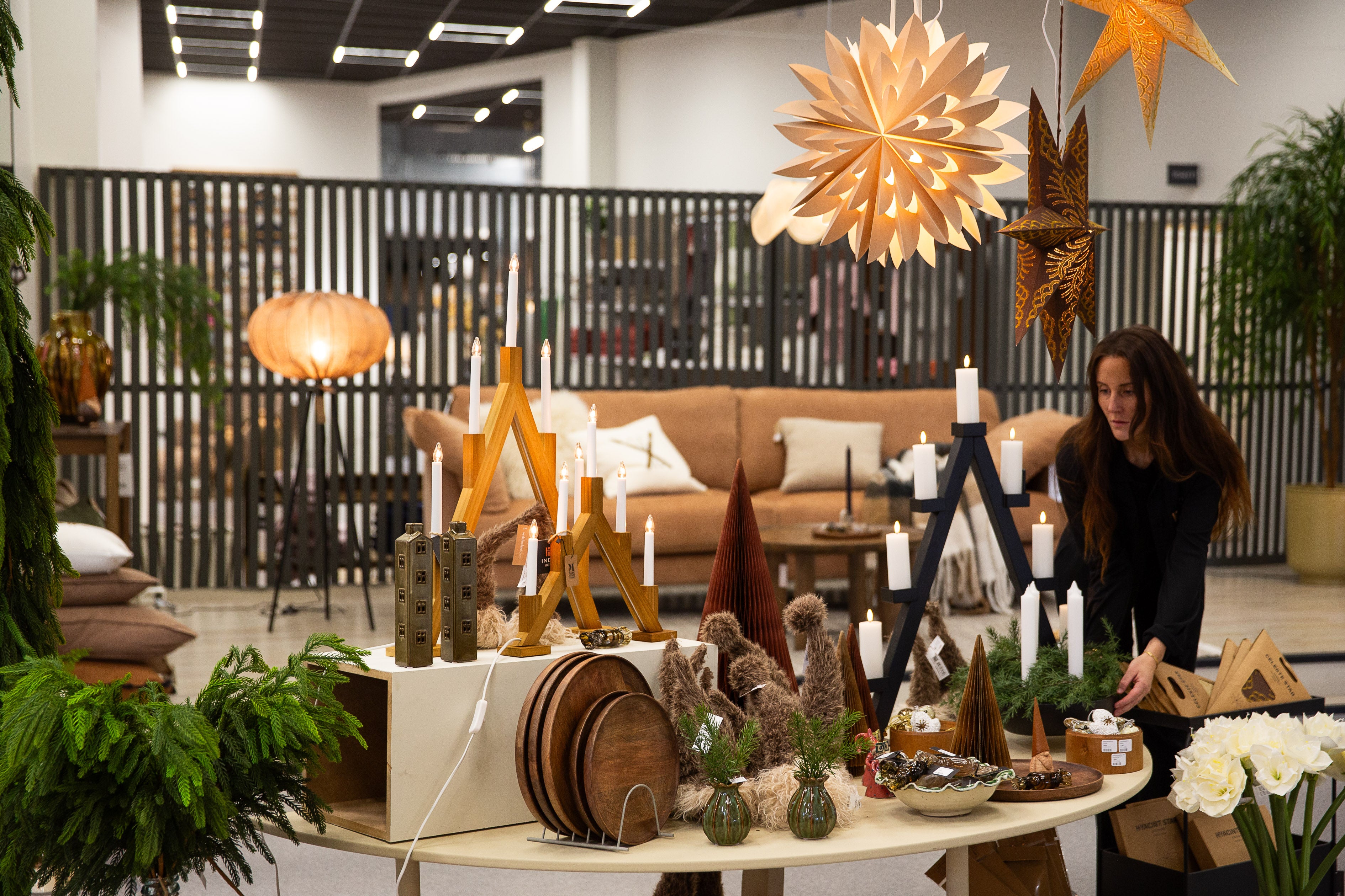 Juldekorationer med ljusstakar, adventsljusstakar i trä och dekorativa stjärnor i modern inredningsbutik